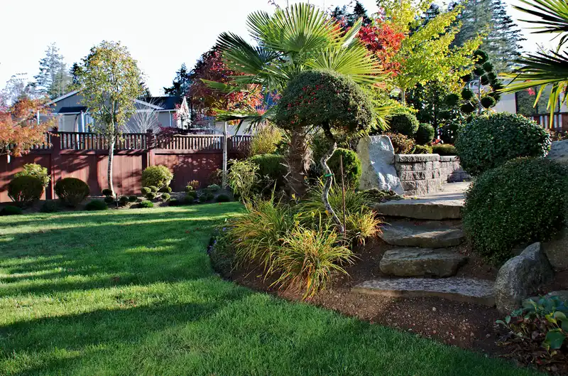 Backyard garden featuring natural stone steps, lush green grass, and topiary shrubs.