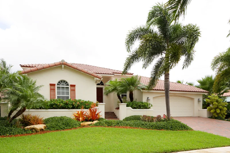 Tropical landscape installation with palm trees and a green lawn.
